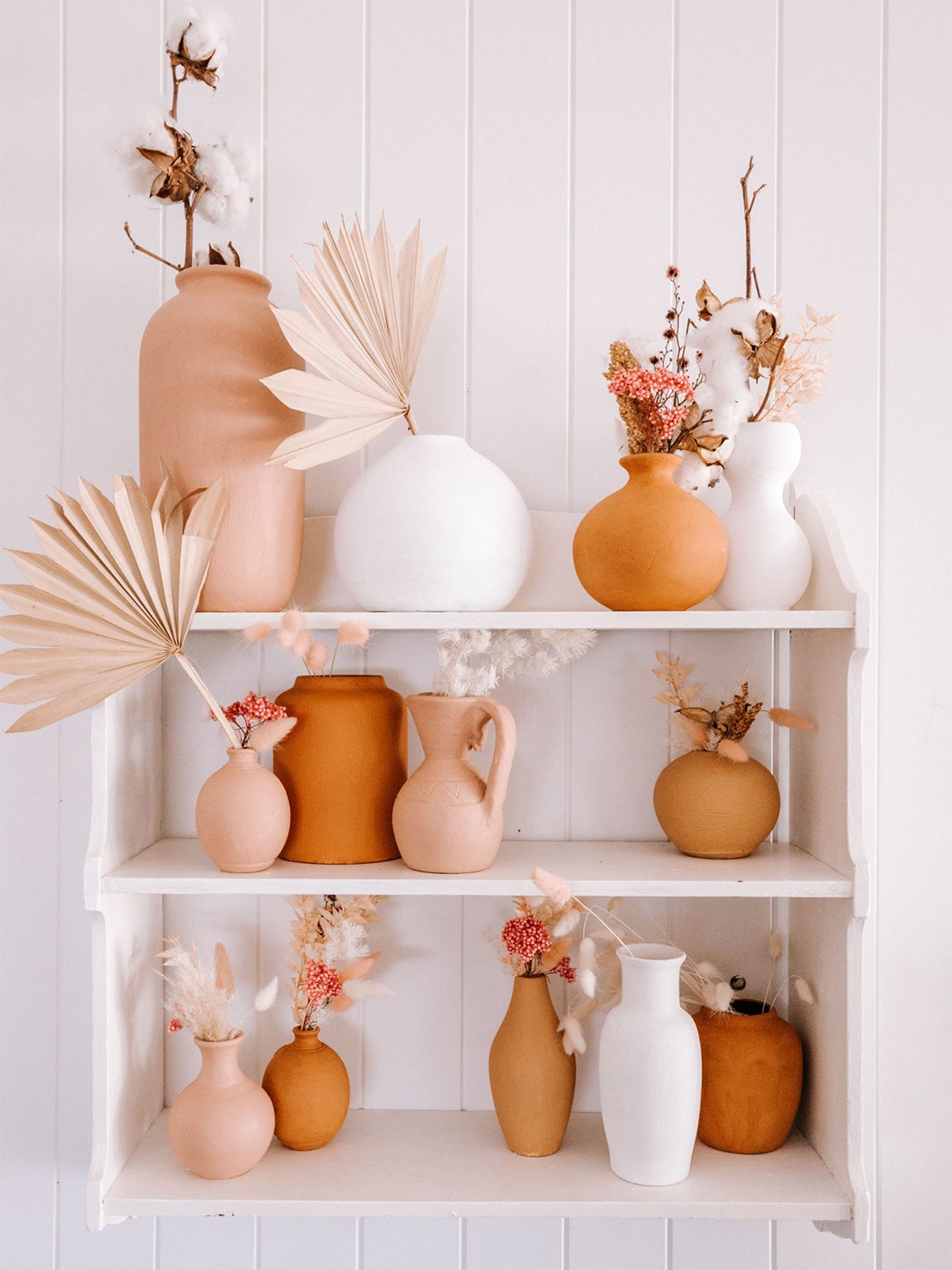 white and orange vases on white shelf