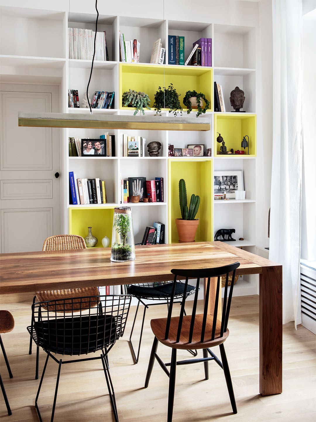 yellow and white painted bookcase wall in dining room