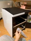 White contact paper being applied to nightstand