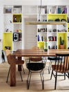 yellow and white painted bookcase wall in dining room