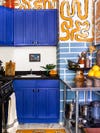 royal blue kitchen cabinets with orange mural