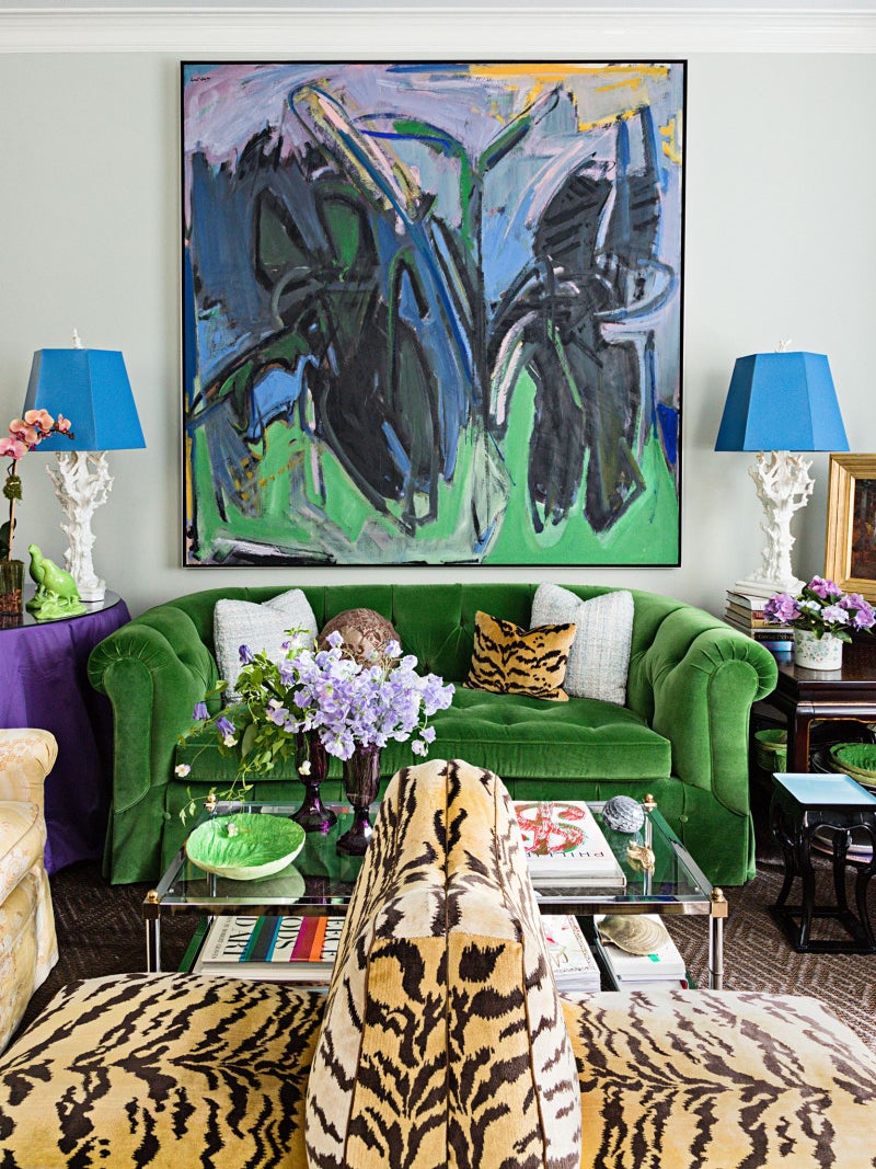 maximalist living room with green sofa and tiger stripe chairs