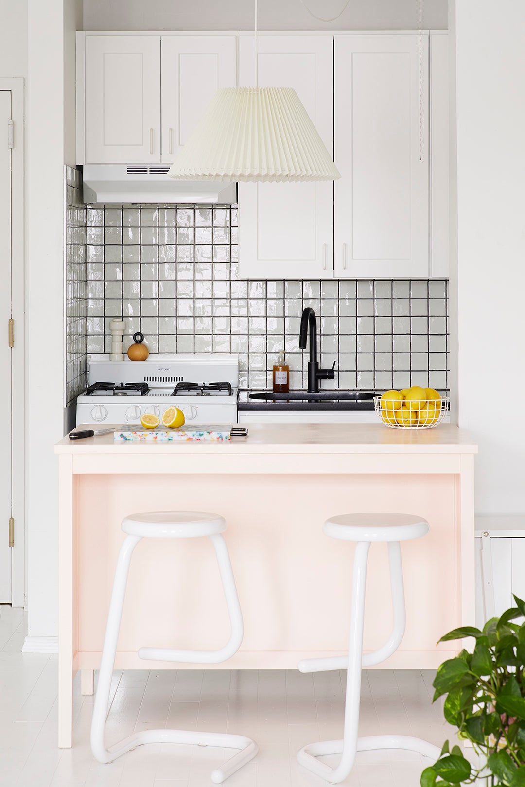 Pink kitchen island with white cabinets
