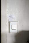 white light switch with note stuck to it