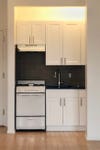 White kitchen cabinets with a black backsplash