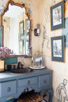 blue powder room with sketches hung on the wall