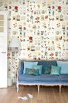 blue sofa in front of floral print wallpaper
