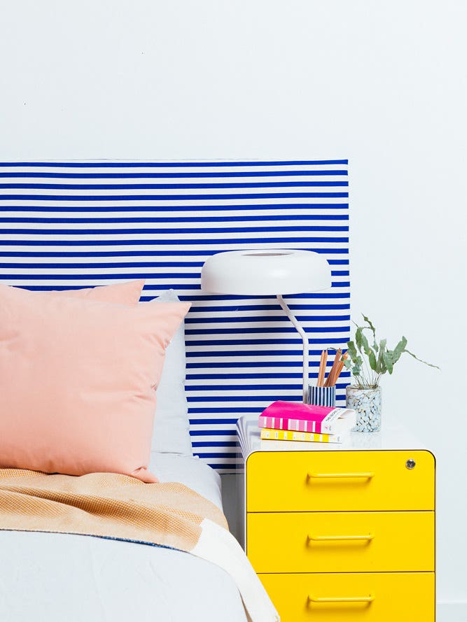 striped blue and white headboard and yellow nightstand
