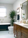 Bathroom with black tub and plant