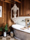 bathtub with elaborate light fixture hanging over it