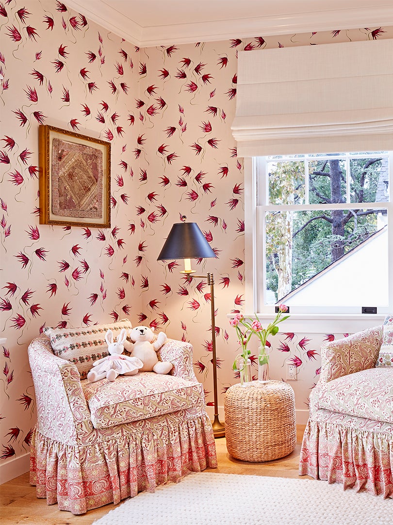 skirted armchairs and red and white floral wallpaper