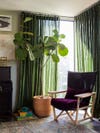 green curtains with a plum chair in a living room