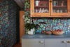 wood and glass cabinets with botanical wallpaper all around