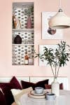 pink breakfast nook with black and white wallpaper shelf