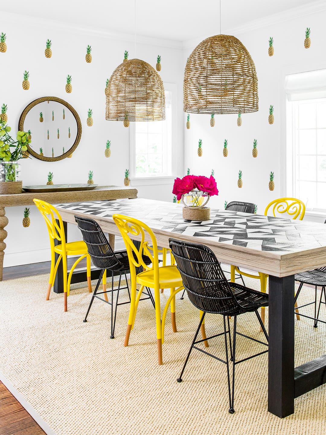 dining room with pineapple decals on wall and yellow chairs