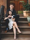 two people sitting on a brownstone stoop