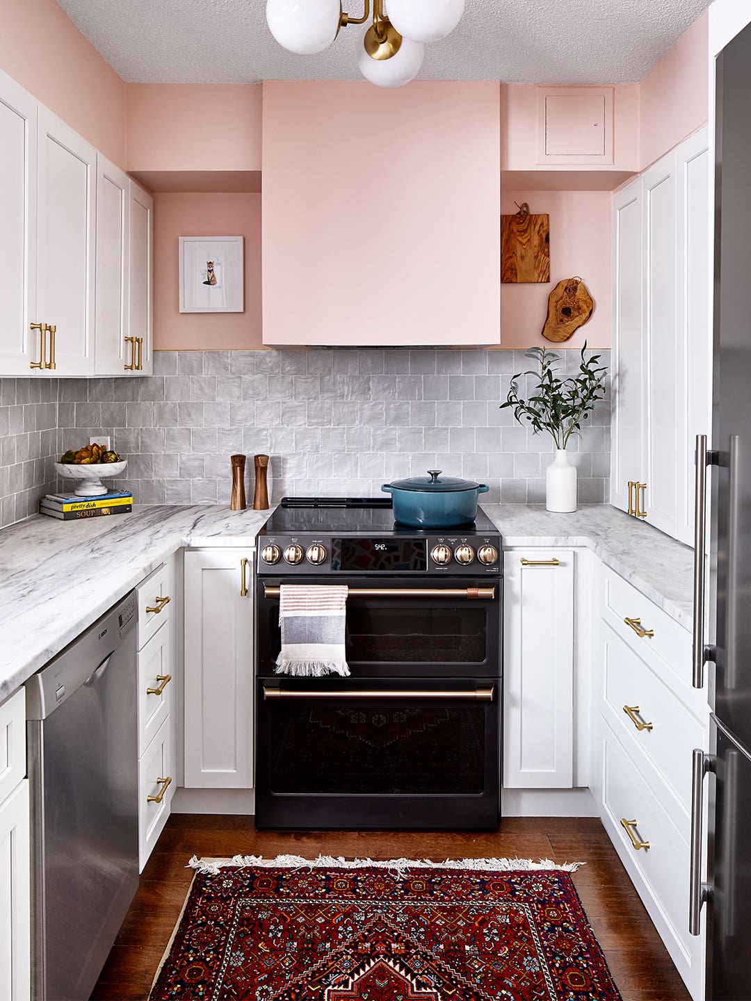 small pink kitchen with black oven