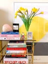 Shelf with colorful books and flowers