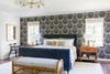bedroom with black and white wallpaper and blue upholstered bed frame
