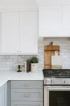 white upper cabinets and lower gray with subway tile backsplash