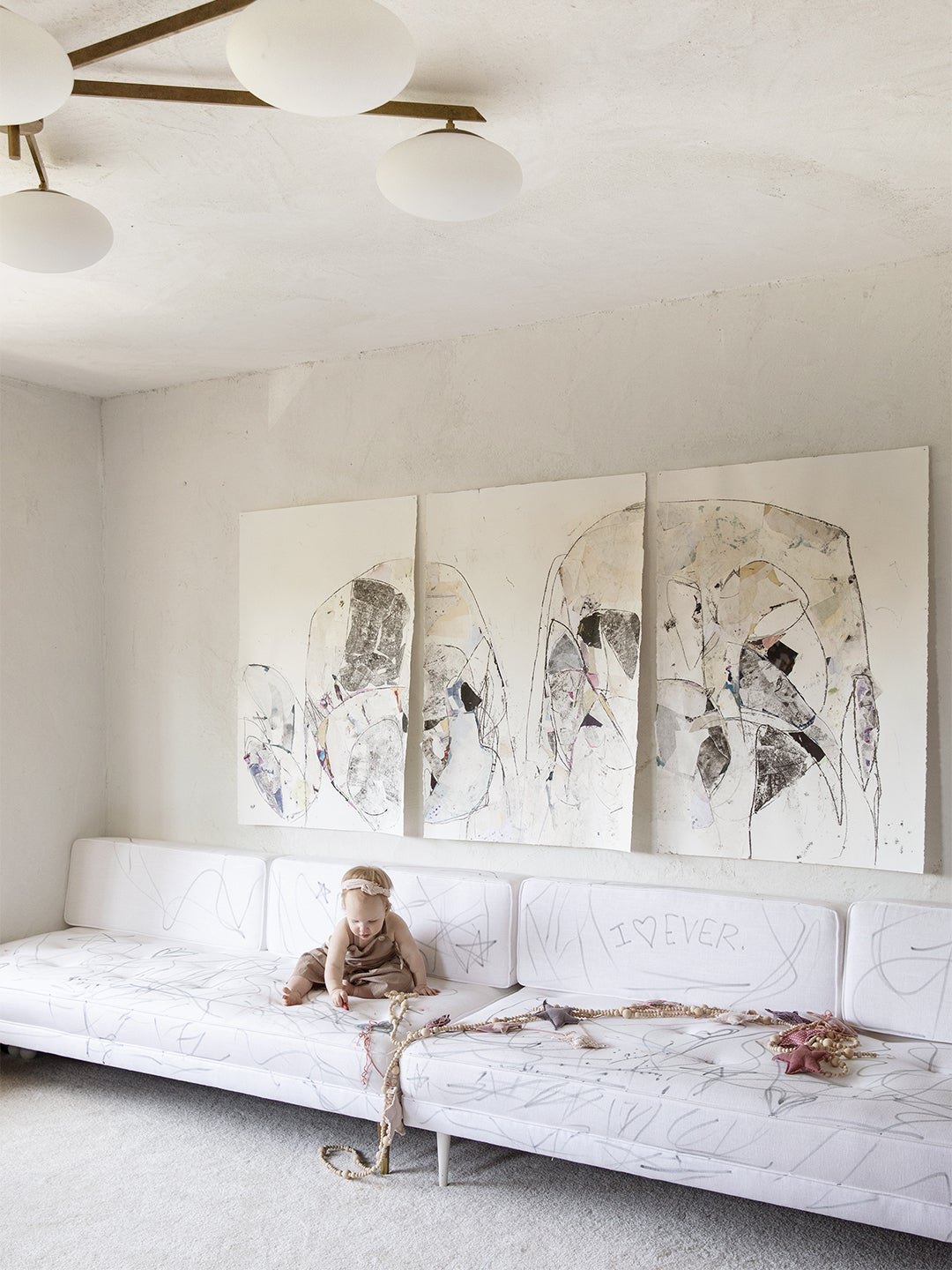 white room with baby on a white sofa
