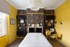 yellow guest room with sculptural pendant