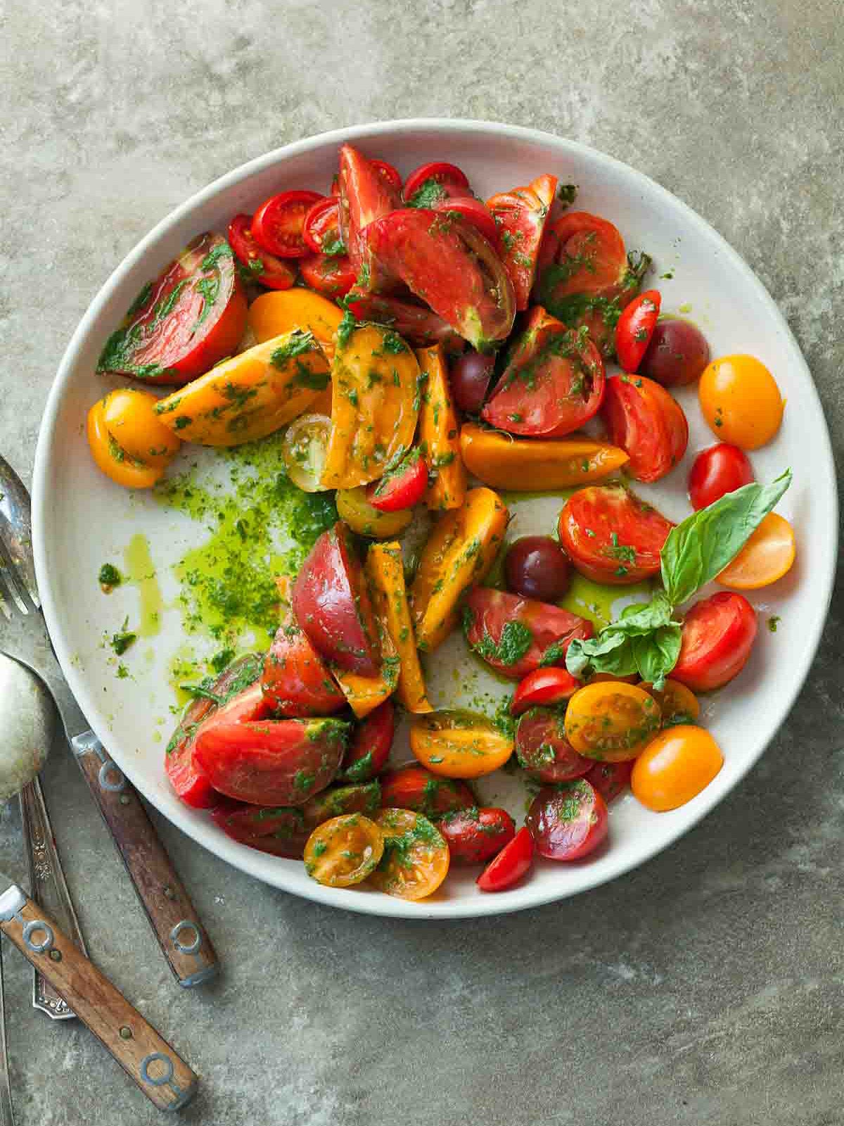 heirloom tomatoes on a plate with herb drizzle