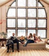 family sitting on sofa by large glass windows