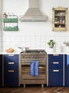blue kitchen with white backsplash tiles