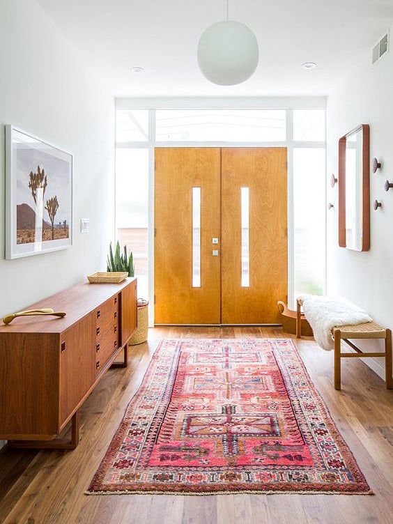 entry with pink rug and mid century console