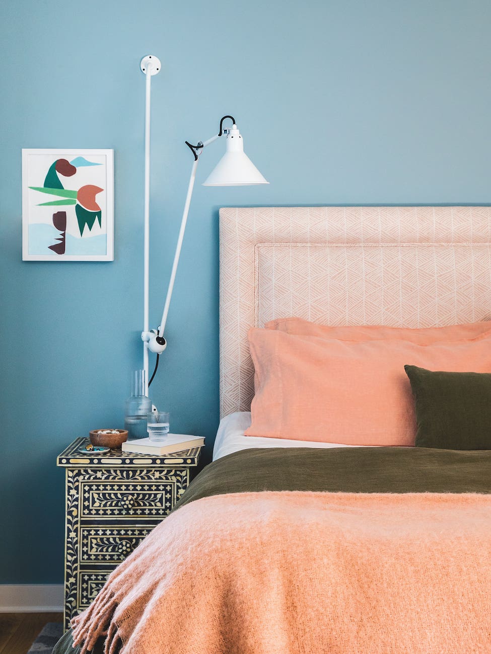 Bedroom with blue walls and peach sheets