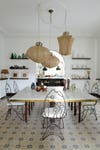 dining room table with fish shaped chairs and three woven pendants