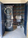laundry closet with two machines and grey sink