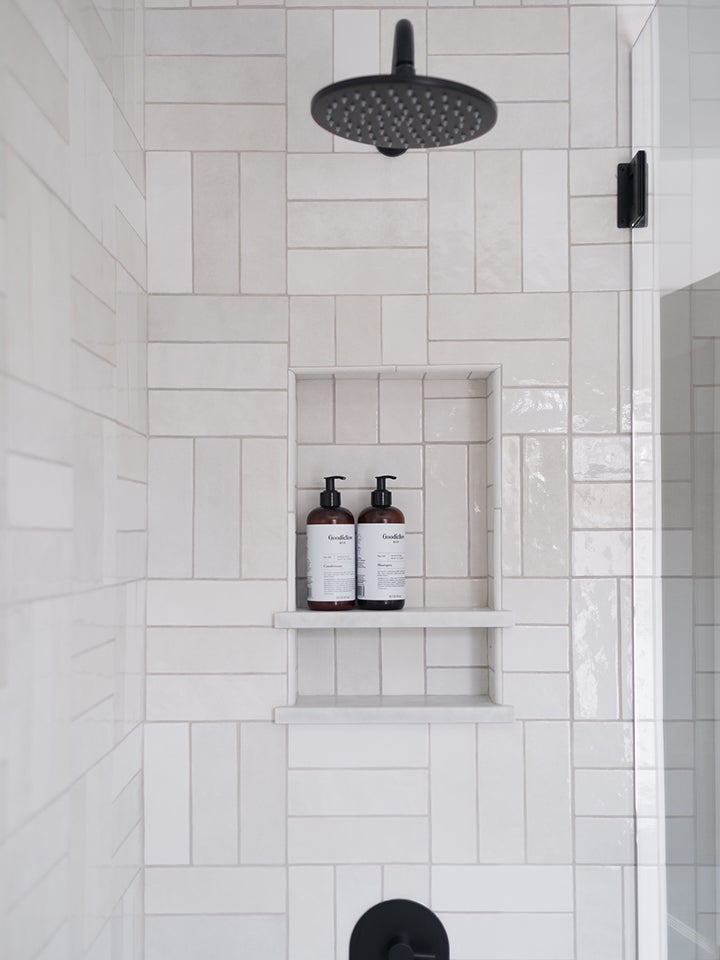 white subway tile shower with niche for shampoo bottles