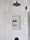 white subway tile shower with niche for shampoo bottles