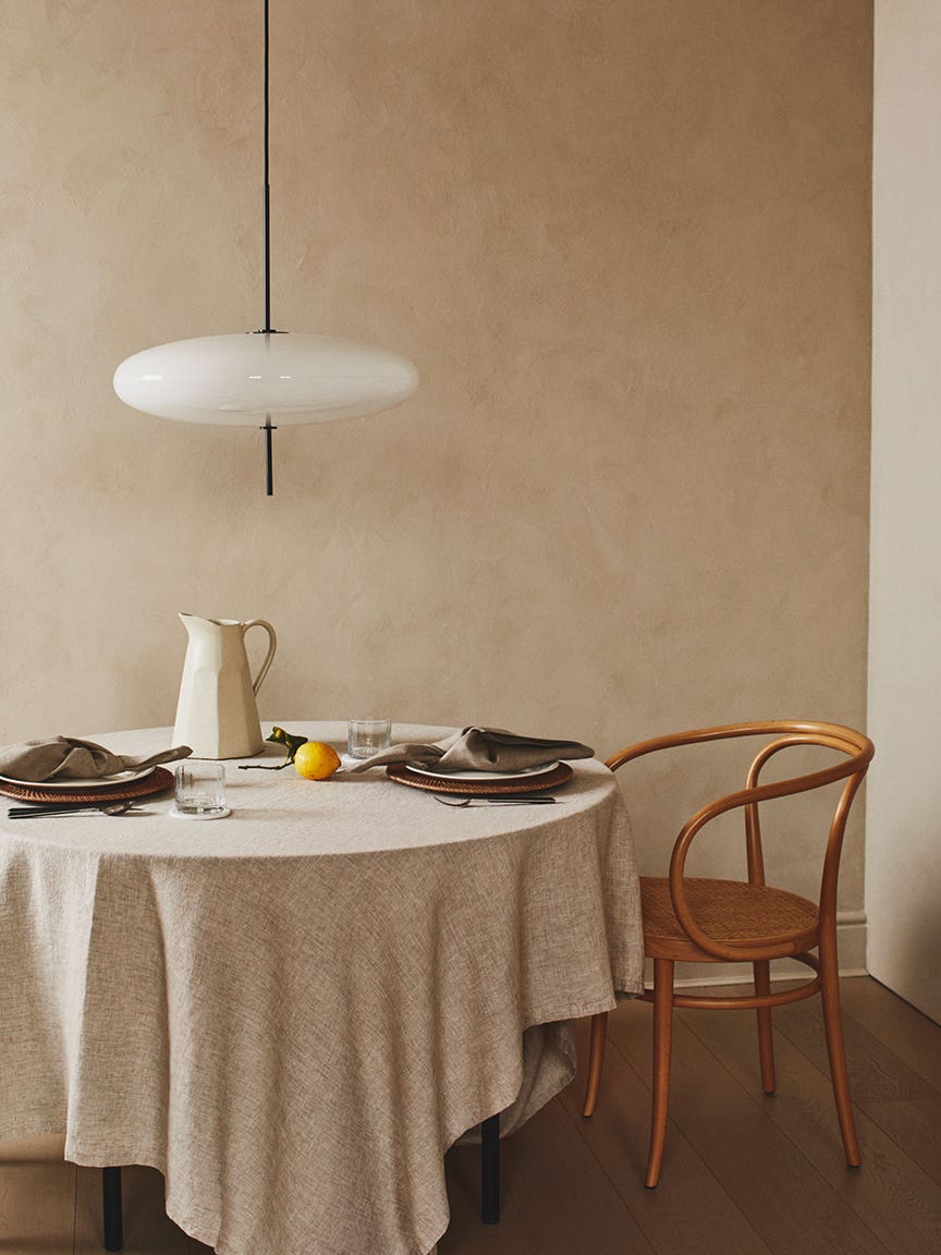 neutral table setting with pendant light and wooden chair