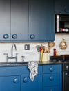blue kitchen cabinets with big round knobs
