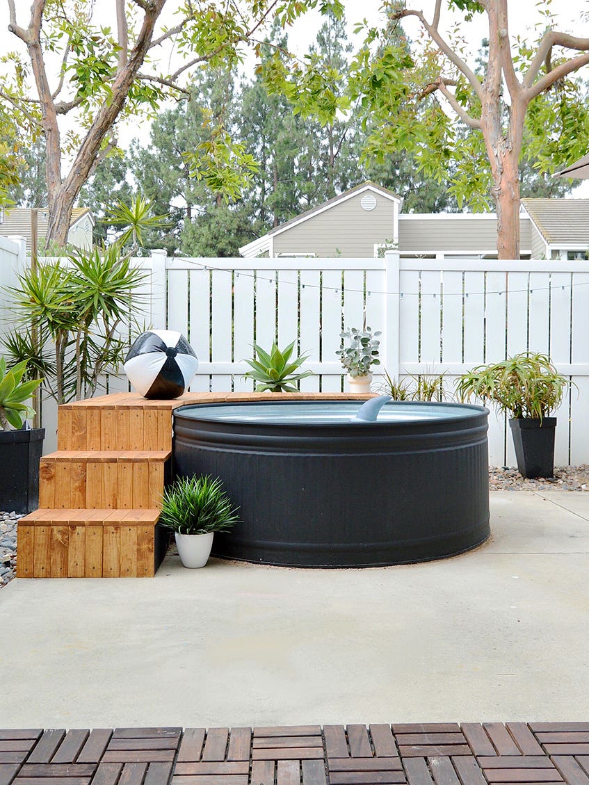 black stock tank pool with wood deck