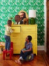 Boys playing in a bedroom with yellow dresser
