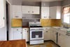 dated kitchen with linoleum checkerboard floors and yellow tile backsplash
