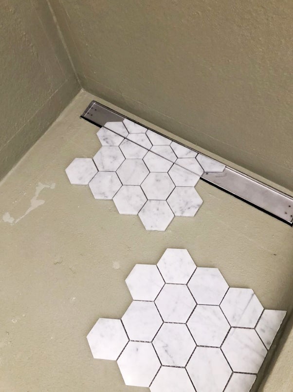 laying white tile on floor