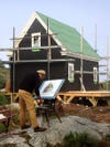 man painting construction of studio