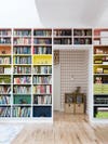 wall of built in bookshelves with rainbow colored backings