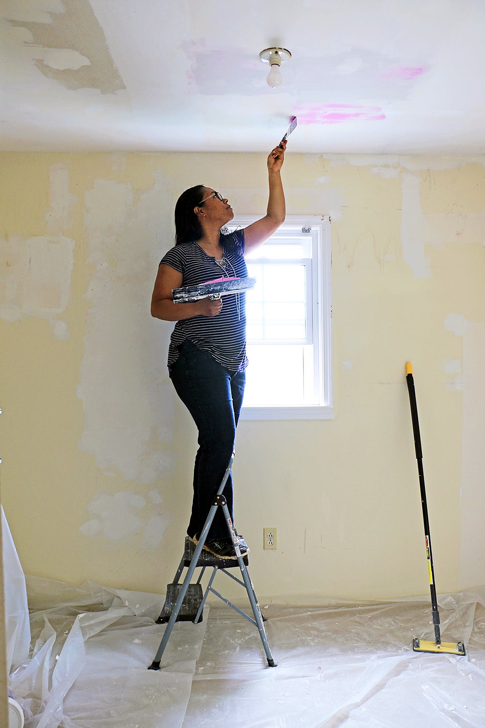 woman scraping ceiling