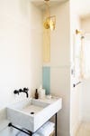 white tile bathroom with gold pendant