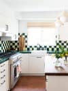 Kitchen with green-and-white backsplash and terracotta floors