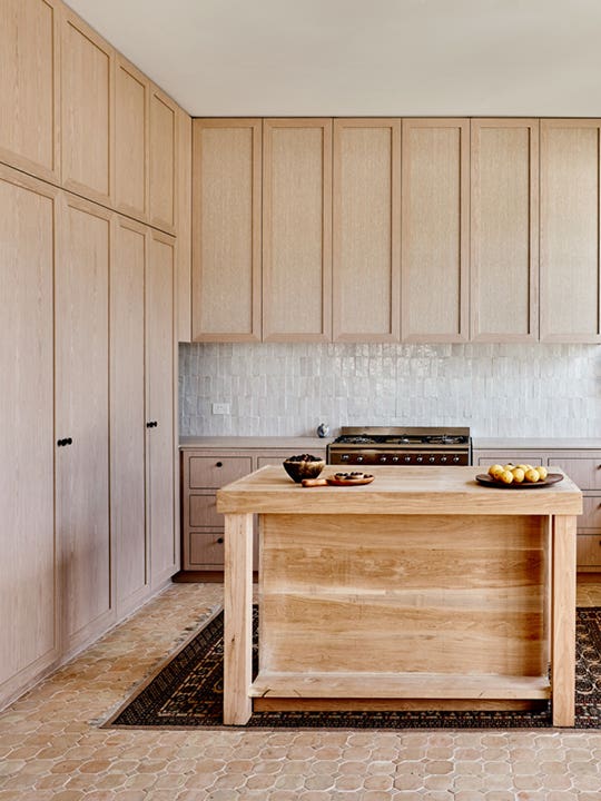 Pale wood kitchen with terracotta floors