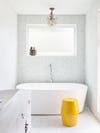 white tile bathroom with yellow stool