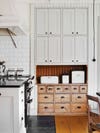 white kitchen with built in antique drawers