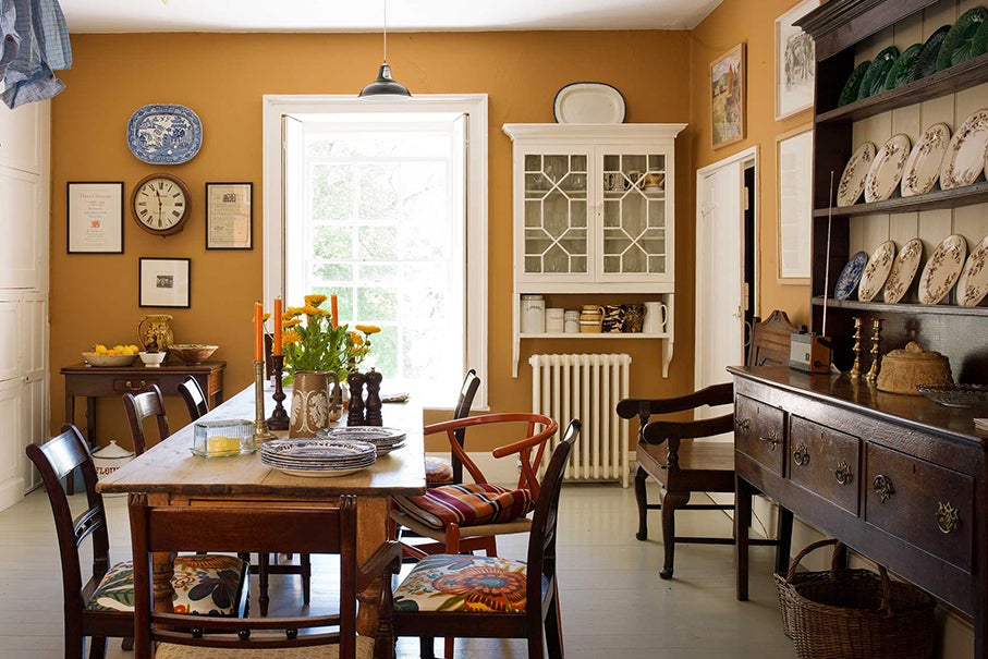 yellow kitchen/dining room with dark wood antique cabinet
